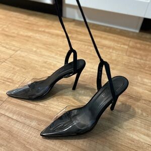 Acrylic toe and black backless heel with ankle straps.